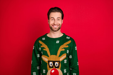 Photo of young cheerful man happy positive smile wear sweater winter new year isolated over red...