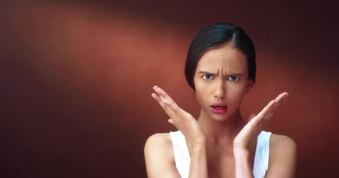 Portrait of toung beautiful woman shows emotion of shock of bad news, and upset by situation actively uses hand gestures.