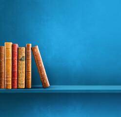 Row of old books on blue shelf. Square background