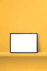 Digital tablet pc on yellow wall shelf. Vertical background banner
