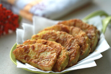 Golden slices of zucchini fried in batter. The red rowan tree symbolizes autumn.