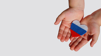 heart - flag of Russia made of felt on children's hands palms on a light background