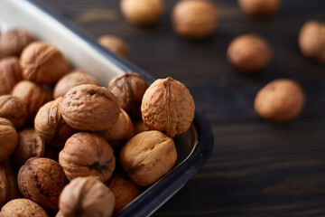 Natural whole walnuts on dark wooden table