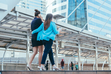 Naklejka premium Two business women walking in city for going to work with cityscape background.