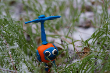 Toy helicopter in the snow-covered grass.