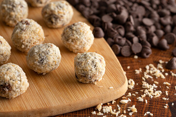 Group of Coconut Chocolate Energy Balls on a Wooden Butcher Block