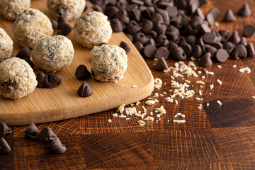 Group of Coconut Chocolate Energy Balls on a Wooden Butcher Block