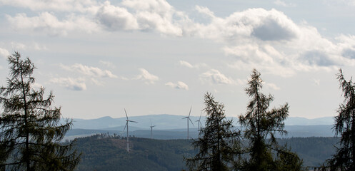 Landscape in Hessen Germany with mountains, few clouds and wind turbines during summer. 