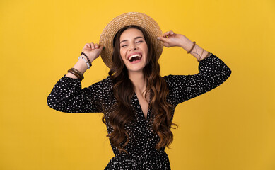 pretty woman posing isolated on yellow background wearing straw hat and dress