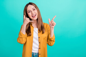 Photo of attractive beautiful mature lady wear yellow shirt showing phone gesture pointing empty...