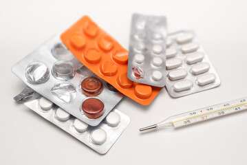 Set of different blisters, pills and medication with thermometer to cure cold, viruses and disease