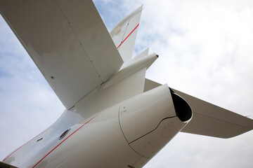 tail of a business jet close-up on background of clouds © alesmunt