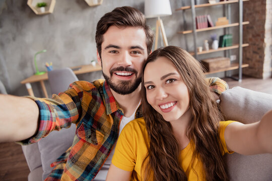 Photo Of Blogger Influencer Couple Take Selfie Toothy Smile Wear Casual Clothes Sit Couch Home Indoors