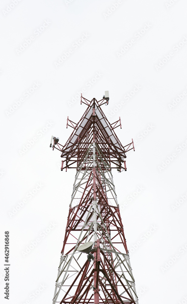 Poster Vertical shot of the tip of white and red cell tower in the fog under white sky