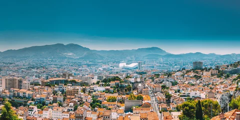 Fotobehang Urban panorama, aerial view, cityscape of Marseille, France. Sunny summer day with bright blue sky. Cityscape of Marseille, France. Urban background with sport Velodrome stadium. Stade Velodrome © Grigory Bruev