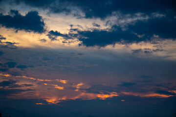 Dramatic colorful sky with gradient lighting in warm and cool colors, black clouds and perspective to the horizon