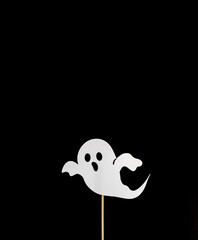 White ghost on a black background. Copy space. View from above. Halloween. Minimal.