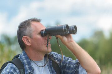 Fototapeta na wymiar Man looking through binocular