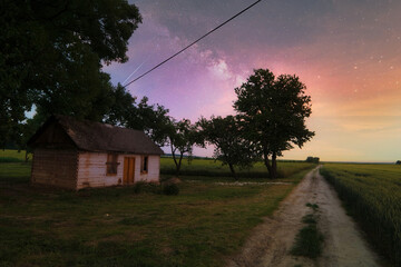 Stary dom w Siennicy R&oacute;żanej na tle kolorowego nieba.
