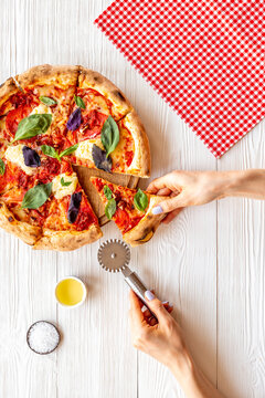 Female Hands Hold Slice Of Pizza. Overhead View