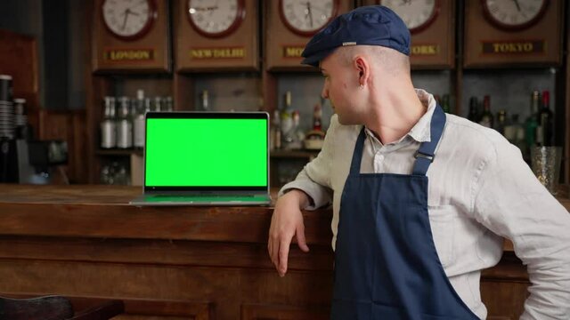 Portrait Of Man Small Business Owner Standing With Tablet Computer In The Cafe Or Coffee Shop. Barista Showing Green Screen Tablet Pc At Camera