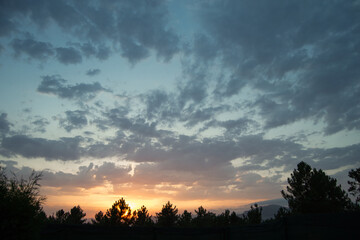 Fototapeta premium Imagen a color de las nubes y el atardecer sobre un cielo azul anaranjado.