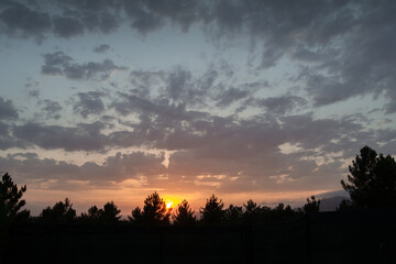Fototapeta premium Imagen a color de las nubes y el atardecer sobre un cielo azul anaranjado.