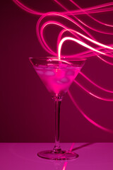 Martini glass with drink and ice against creative lighting