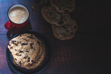 Galletas con chispas de chocolate y café sobre una mesa de madera