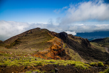 A beautiful view on mountains, sky, clouds and person figure hiking, near active volcano Aso in Kyushu, Japan