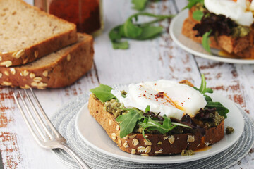 Homemade sandwiches with pesto, green salad and poached eggs
