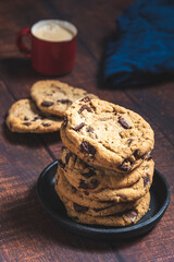 Galletas con chispas de chocolate y café sobre una mesa de madera