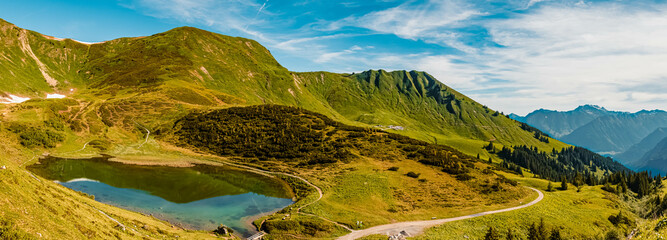 High resolution stitched panorama of a beautiful alpine summer view with reflections in a lake the famous Fellhorn summit near Oberstdorf, Bavaria, Germany