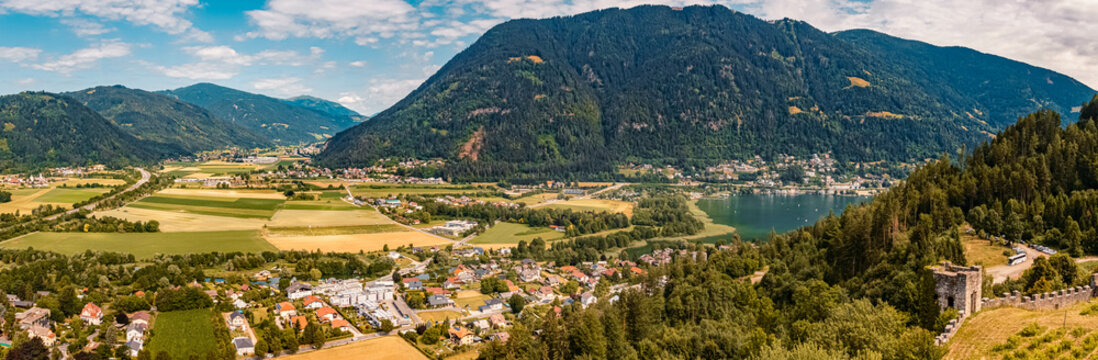 High resolution stitched panorama of a beautiful alpine summer view with the Ossiach lake at the famous Landskron castle ruins, Villach, Kaernten, Austria