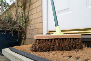 Typical stiff outdoor broom seen on a doorstep and mat at the back of a house. Used to keep the...