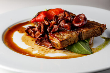 Meat steak with sauce and mushrooms.