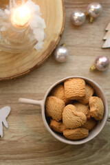 Bowl of cinnamon cookies, lit candles and various Christmas decorations on the table. Flat lay.