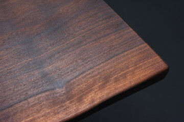 Style wooden countertop slab, saw cut wood treated with varnish close-up on black. Isolate.