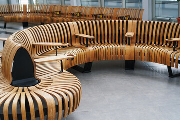 Modern curved wooden bench at the airport