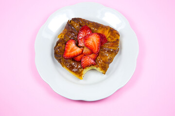 Bitten Puff pastry bun or roll. Cake with fresh strawberries. Delicious sweets temptation and...