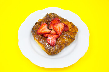 Puff pastry bun or roll. Cake with fresh strawberries. Delicious sweets temptation and desserts on a yellow background. Minimalism, original and creative image. Beautiful food wallpaper.