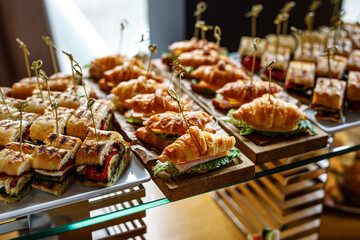 Stacks of croissant sandwich at event.