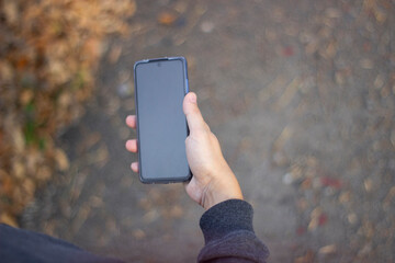 Closeup image of male hand holding smartphone with blank screen. Mockup ready for text message or content. Man's hands with cellphone. Empty display.