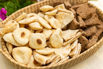 Uma cesta cheia de pães variados em mesa de buffet.