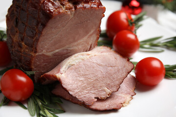Cut delicious ham with rosemary and tomatoes on white plate, closeup