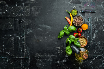 Aromatic fresh herbs and spices on a black background. Top view with copy space.