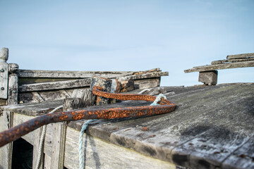 Close up rusted steering tiller on old wooden fishing boat at Dungeness, Kent, England