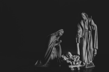 black and white wood nativity figures with copy space on black background