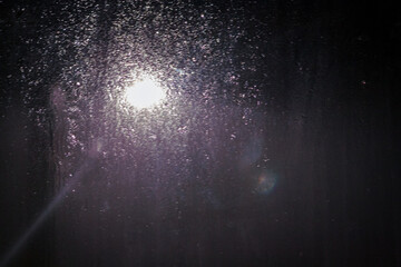 rain drops on the window with street light