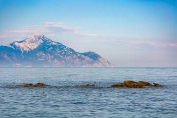 The sacred Mount Athos in Greece seen from Kassandra peninsula in Halkidiki with clear blue sky in...